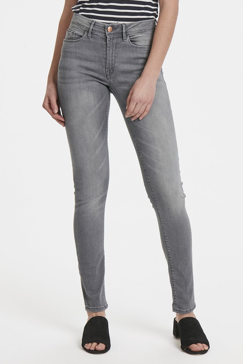 Jeans skinny grises de mezclilla, con una cintura alta, diseño de cinco bolsillos y un lavado sutil. Combinados con mules negros de punta abierta.