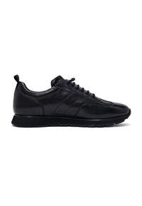 Zapatillas de cuero negro con una superficie suave, punta redondeada, diseño de perfil bajo y acentos texturizados; acabadas con una suela de goma.