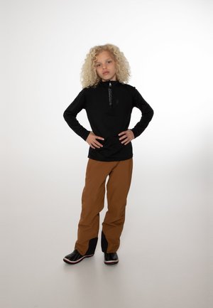 Schwarzer Quarter-Zip-Pullover, braune weite Hose und schwarze Stiefel mit roten Akzenten. Glattes Material, lockere Passform und minimalistisches Design.