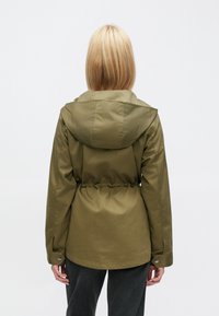 Λαδί πράσινο μπουφάν με κουκούλα, ελαστική μέση, μακριά μανίκια, μανσέτες με κουμπιά και λεία υφή· διαθέτει στενή εφαρμογή και πρακτικό σχεδιασμό.