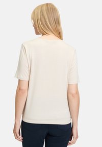 Beige kortærmet T-shirt med rund hals og afslappet fit, lavet af blødt stof, med en glat tekstur og uden synlige mønstre.