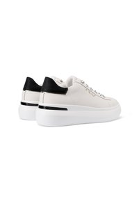 Sneakers bianchi in pelle con un accento nero sul tallone e suola piatta bianca. Presentano occhielli metallici e un marchio decorativo sul lato.
