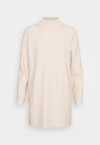Light beige knitted sweater dress with a high ribbed collar, long sleeves, and a textured diamond pattern throughout. Soft, loose fit.