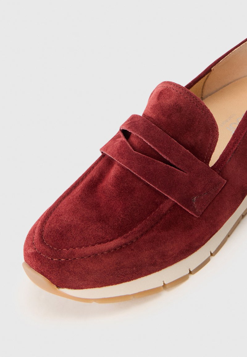 Rode suède instapper met een platte rubberen zool, voorzien van een voorste band en gestikte details rond de rand en de tenen.
