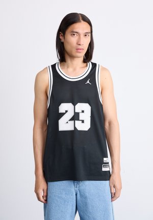 Juodas krepšinio marškinėliai su baltonu tinklu, numeris 23 ryškiai baltu, apvalus kaklo iškirpimas su baltu apvadu ir mažas Jordan logotipas ant krūtinės.