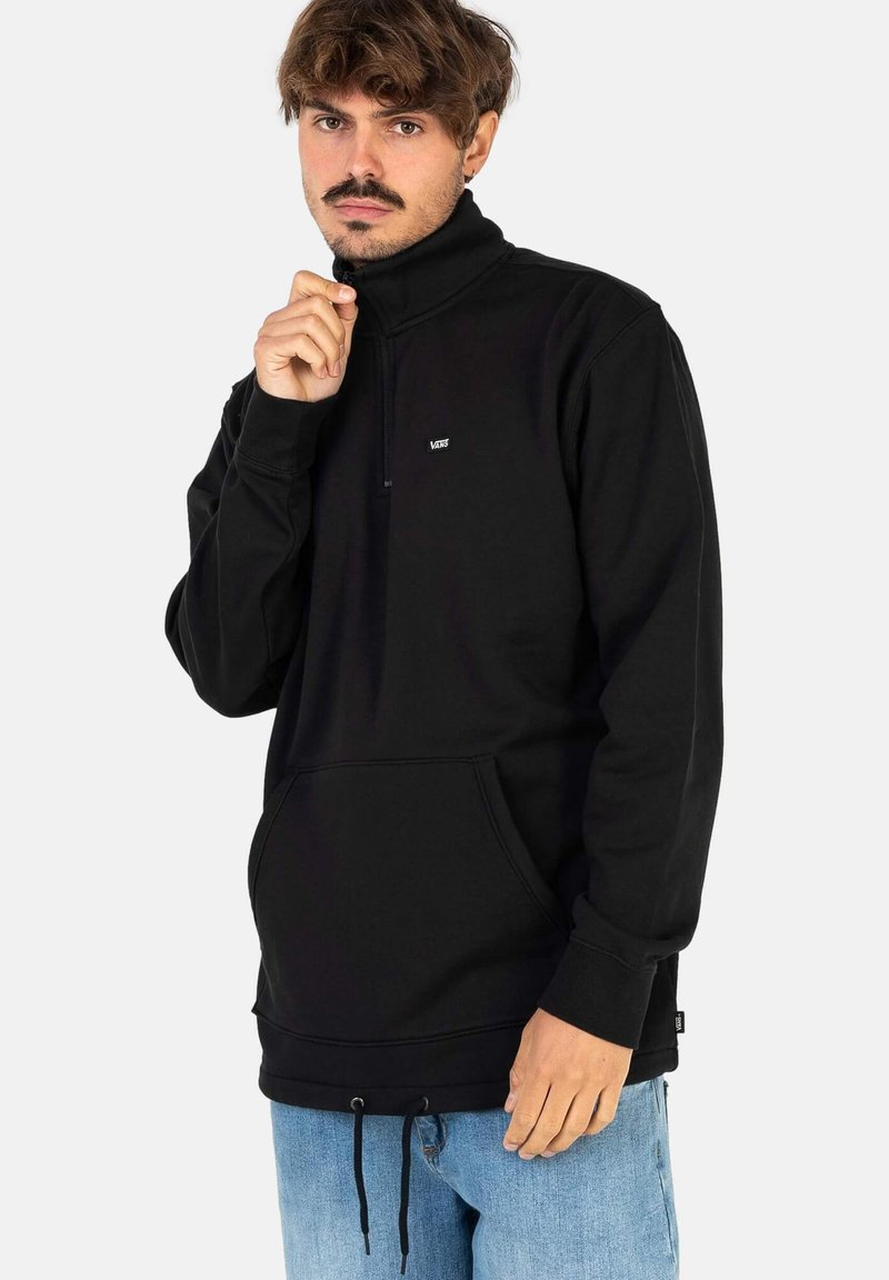 Maglione nero con colletto alto e mezza zip, dotato di tasca frontale e cordoncino regolabile all'orlo. Tessuto morbido.