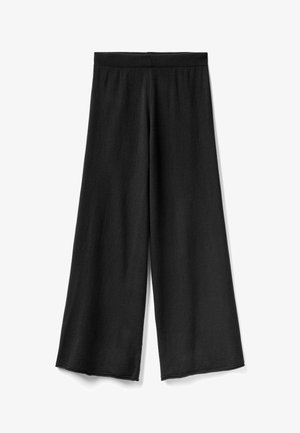Czarne spodnie o szerokich nogawkach wykonane z miękkiego materiału, z gładkim, elastycznym paskiem w talii i prostym, luźnym krojem bez widocznych wzorów.