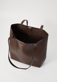 Borsa a spalla in pelle marrone con due manici, apertura superiore, tasca interna con bottone a pressione e piccolo logo dorato sul davanti.