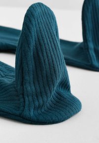 Tessuto a maglia verde acqua con coste, caratterizzato da picchi rialzati, che mostra una consistenza morbida e una forma strutturata. Due pezzi disposti con curve e pieghe.