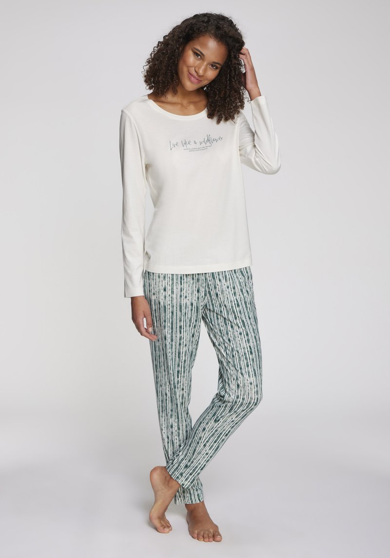 Haut à manches longues en crème clair avec du texte, associé à un pantalon de pyjama rayé vert. Tissu doux, coupe décontractée et design simple.