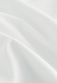 Hvidt stof med en glat, let struktureret overflade, der viser bløde folder og subtil glans, hvilket indikerer et let og luftigt design.