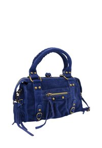 Sac à main en daim bleu marine avec deux poignées, poche zippée sur le devant, accents en matériel doré et pompons latéraux ; forme rectangulaire compacte.