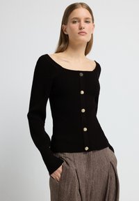 Schwarzer gerippter Cardigan mit langen Ärmeln und quadratischem Ausschnitt, ausgestattet mit sechs goldfarbenen Knöpfen auf der Vorderseite. Weiche Textur und taillierte Passform.