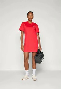 Red athletic dress with a V-neck and short sleeves, made of lightweight fabric. Features an Adidas logo and paired with a black gym bag.