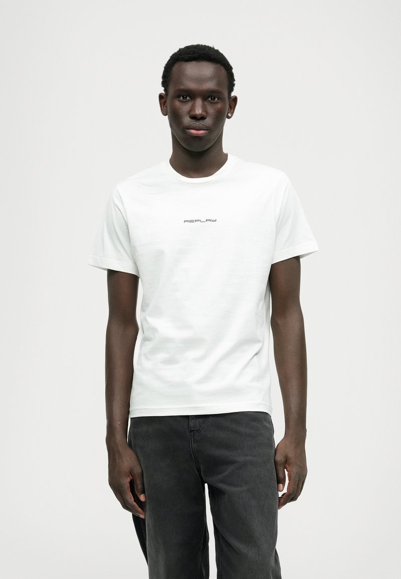 T-shirt de algodão branca com decote redondo e mangas curtas, com "REPLAY" impresso em uma fonte moderna e ousada no peito.