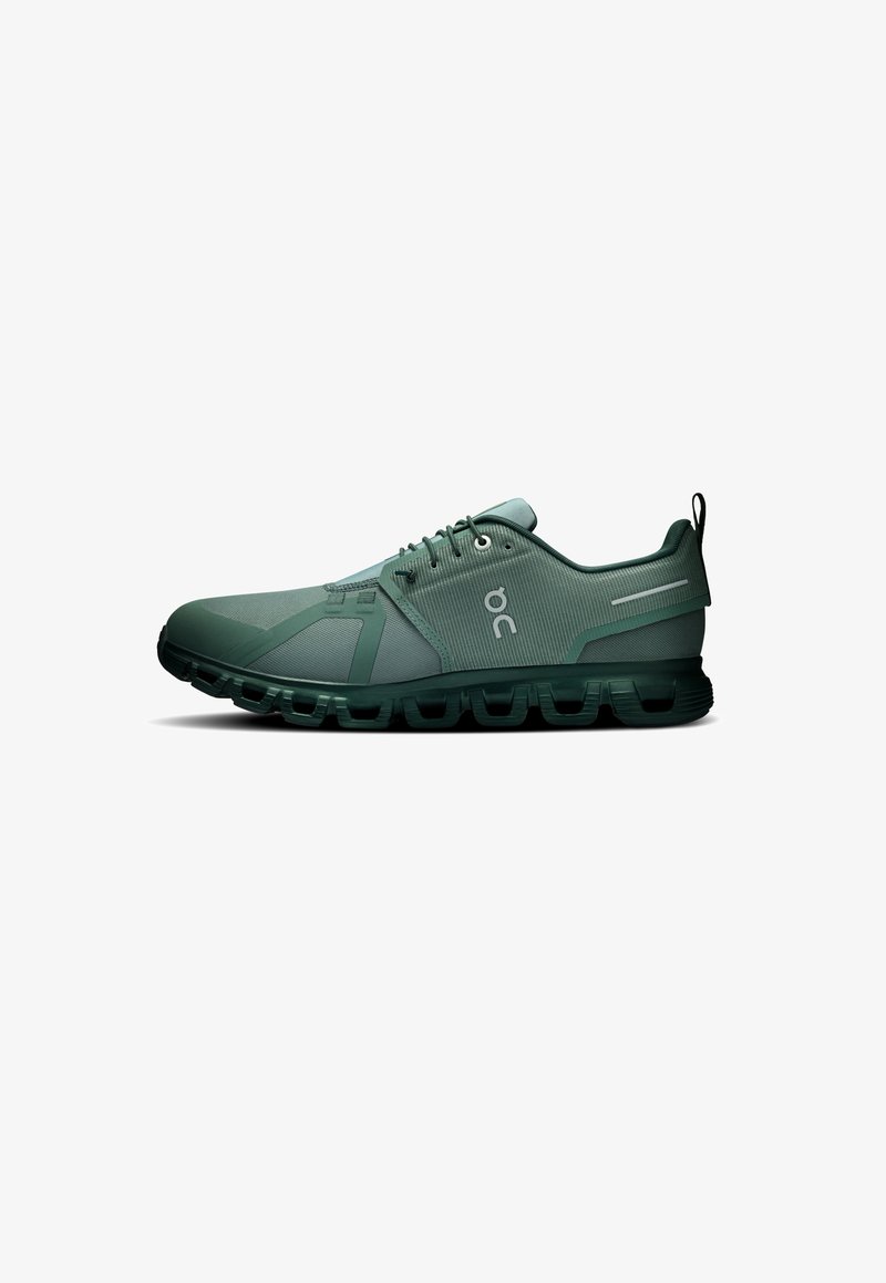 Green running shoes with a textured upper, lacing system, and a cushioned sole featuring segmented cushioning for flexibility.