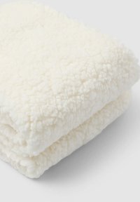 Biała, puszysta kołdra, złożona, aby pokazać miękką, teksturowaną powierzchnię. Materiał wydaje się być pluszowy z lekko nieregularnym wzorem, lekkim designem.