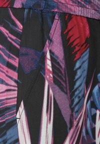 Tissu multicolore présentant un motif abstrait audacieux avec des nuances de rose, rouge et bleu sur un fond noir, texture lisse et fin coutu.