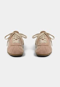 Suede tenisice u svijetlo ružičastoj boji s bež čipkastim vezivanjem. Zaobljeni vrh i teksturirani gornji dio. Gumeni potplat s vidljivim detaljima šivanja.