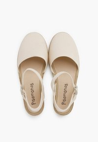 Beige canvas sandalen met een ronde neus en enkelbandjes. Platte zool met een tekstuur in de binnenzool. Minimalistisch ontwerp met een natuurlijke uitstraling.