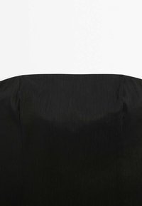 Black fabric with a smooth texture, featuring subtle sheen and pleated design, predominantly covering the backrest of a chair.