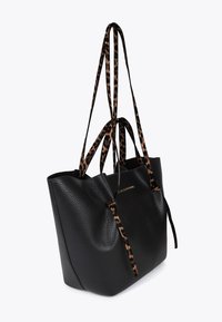 Black textured leather tote bag with leopard print straps and a simple design. Features a secure closure and a spacious interior for storage.