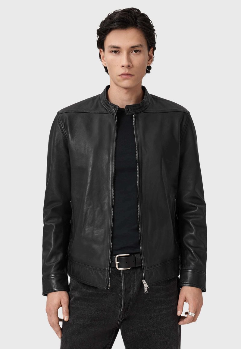 Zwarte leren jas met een staande kraag, soepel textuur en een rits aan de voorkant. Heeft subtiele stiksels en een getailleerd ontwerp.