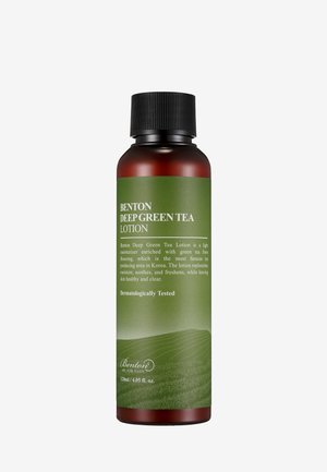 Lotion au thé vert profond Benton, 120 ml, présente une bouteille en ambre foncé avec un bouchon à vis noir et une étiquette verte affichant les détails du produit et des images de champs.