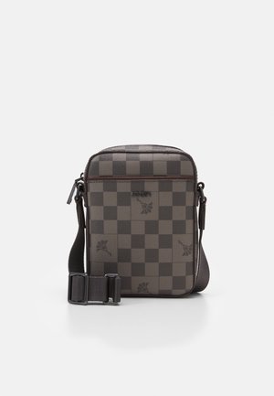 Sac bandoulière avec un motif à carreaux gris foncé, extérieur en cuir, sangle réglable et fermeture éclair. Présente des accents floraux subtils.