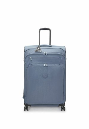 Blue fabric suitcase with a textured surface, two zipper compartments, four wheels, and a retractable black handle. Features a keychain accent.
