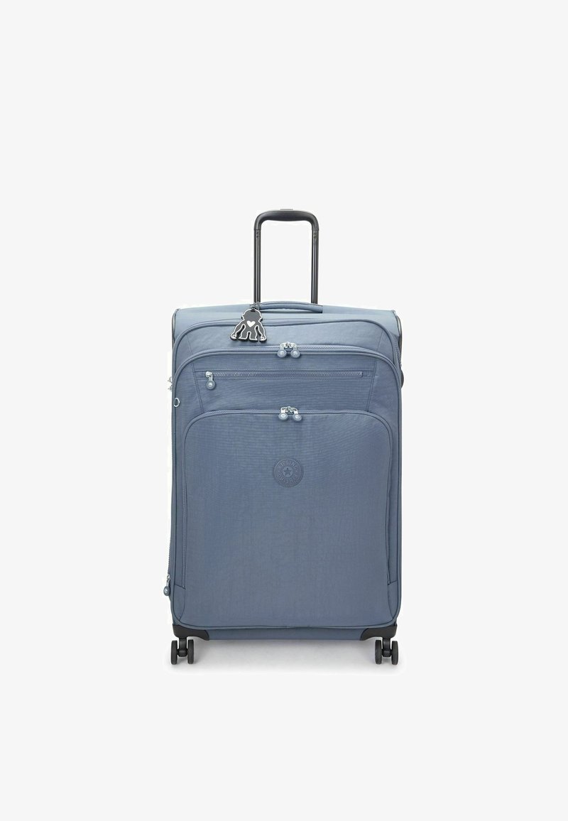 Valigia in tessuto blu con superficie texture, due scomparti con zip, quattro ruote e un manico nero retrattile. Presenta un accento a forma di portachiavi.