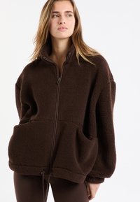 Br�ązowa bluza z polaru z suwakiem do ćwiartki, o teksturowanym wykończeniu, oversized, z dwoma przednimi kieszeniami i regulowanym sznurkiem u dołu.