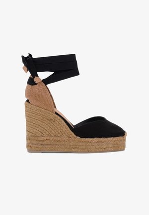 Espadrillas zeppa con tomaia in tela nera, piattaforma intrecciata in juta naturale e cinturini alla caviglia neri con dettagli in pelle marrone al tallone.