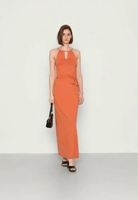 Vestido maxi em laranja queimado, com decote halter e detalhe em buraco-chave, cintura ajustada com cinto combinando e uma silhueta fluida.
