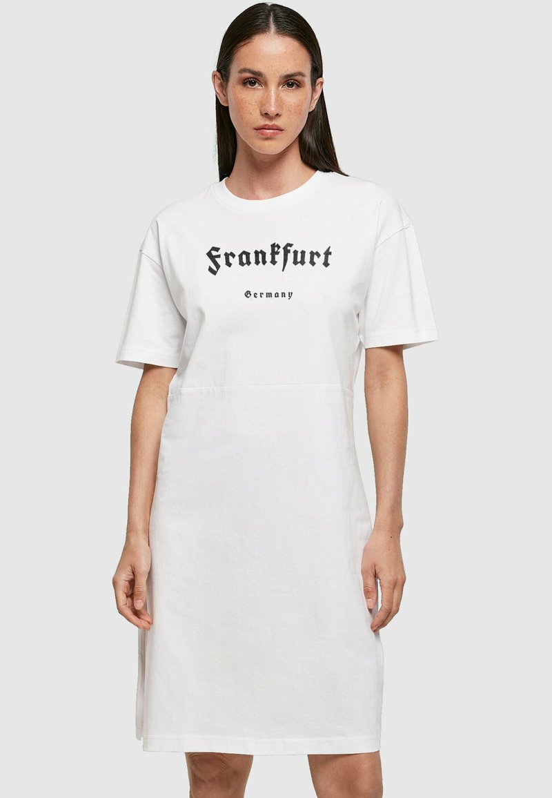 Fehér pamut t-shirt ruha rövid ujjal, amelyen fekete szöveg olvasható: "Frankfurt Németország" vastag betűkkel. Egyszerű, egyenes vonalú fazon.