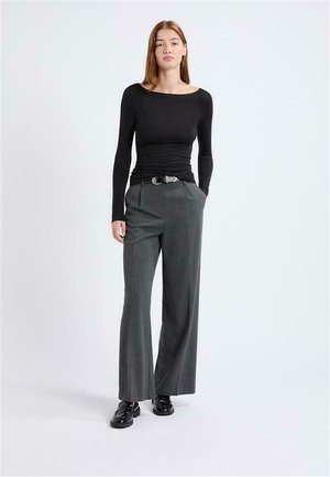 Black long-sleeve top with a round neckline, paired with gray wide-leg trousers featuring pleats and a belt. Black shoes complete the outfit.