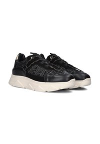 Zwarte sneakers met een textuur bovenkant, voorzien van metalen accenten en een vetersluiting. Chunky witte zool met een driehoekig patroon.