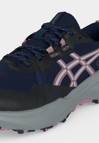 Αθλητικά παπούτσια ASICS σε ναυτικό μπλε και ροζ με κορδόνια με σχέδια, μαλακή σόλα και υφή για καλύτερο κράτημα, σχεδιασμένα για τρέξιμο σε μονοπάτια.
