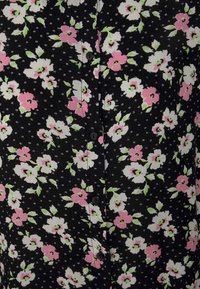 Tecido preto com um padrão floral apresentando flores em rosa, branco e verde. Inclui botões pretos correndo ao longo do centro.