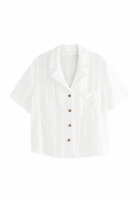 Camisa blanca de manga corta con botones, de tela texturizada, con un bolsillo en el pecho y botones marrones.