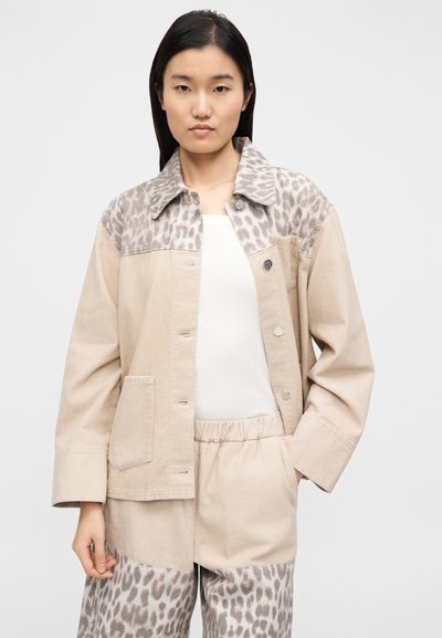 Μπεζ μπουφάν από κορντόρι με λεπτομέρειες λεοπάρ στο γιακά και το άνω μέρος, με κουμπιά και μπροστινή τσέπη.
