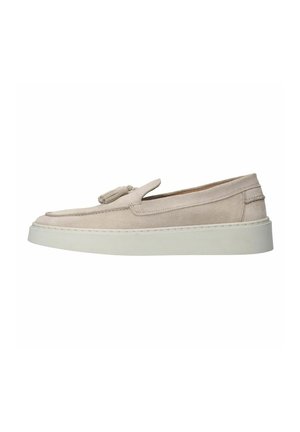 Beige suede slip-on shoes with a textured finish, featuring a decorative tassel, and a white rubber sole, slightly elevated in design.