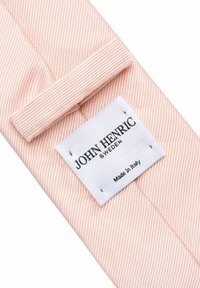 Rosa randig tyg med en texturerad yta, med en vit etikett som visar "JOHN HENRIC SWEDEN" och "Made in Italy" i svart tryck.