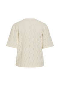 Blouse crème à manches courtes avec un motif en nid d'abeille texturé et une coupe ample, vue de dos.