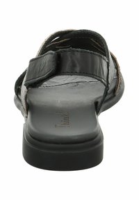 Sandal in pelle nera con design intrecciato, cinturini regolabili e suola piatta. Superficie testurizzata e branding sottile sulla soletta.