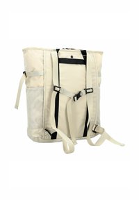 Zaino in tessuto beige con spallacci imbottiti, dettagli neri, apertura superiore con zip, tasca frontale in rete e cintura laterale regolabile per un facile trasporto.
