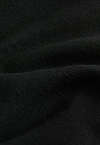 Crni pleteni materijal s glatkom teksturom, koji prikazuje suptilne melirane uzorke i fine rebraste detalje. Materijal izgleda rastezljivo i izdržljivo.