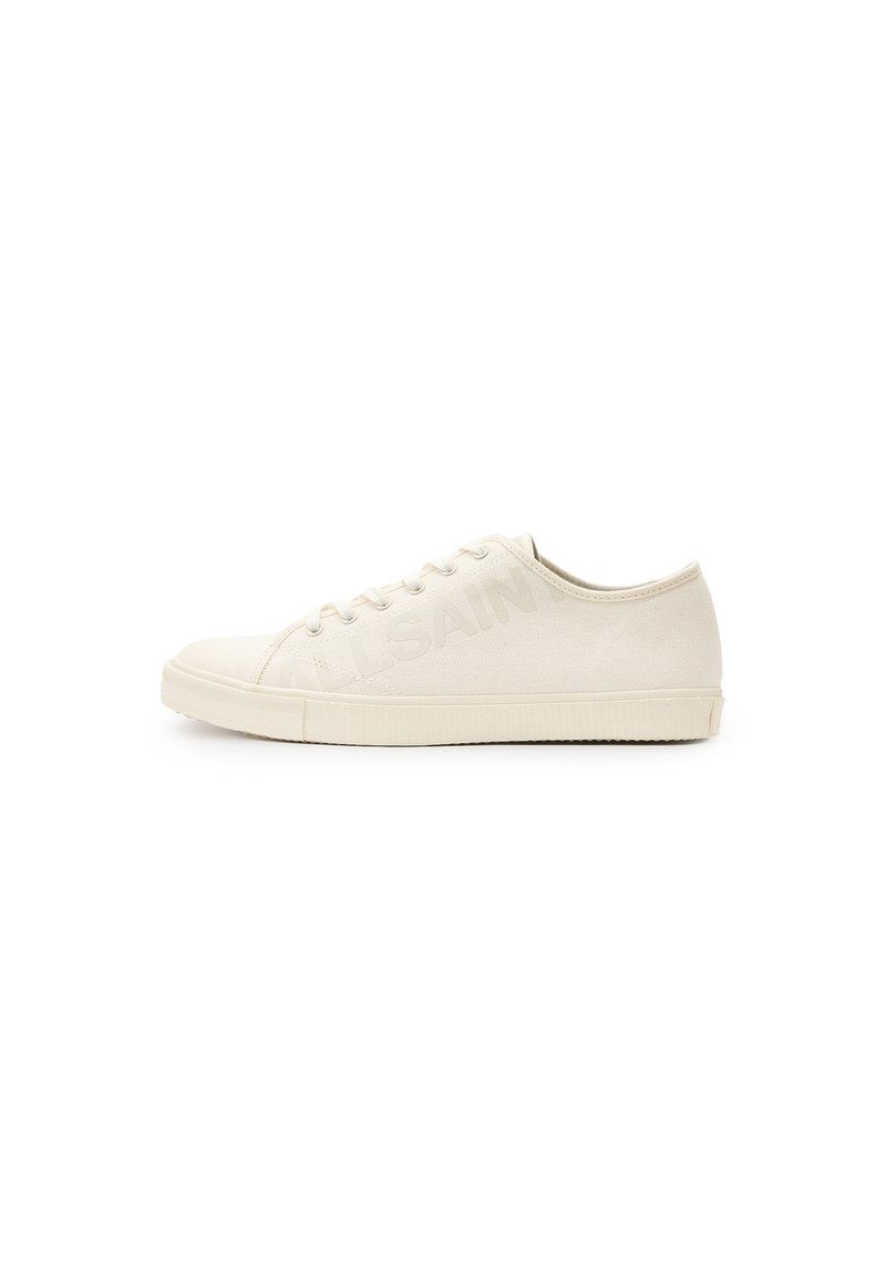 Sneaker in tela beige con punta arrotondata, chiusura con lacci e suola in gomma texturizzata. Presenta un logo del marchio leggermente impresso sul lato.