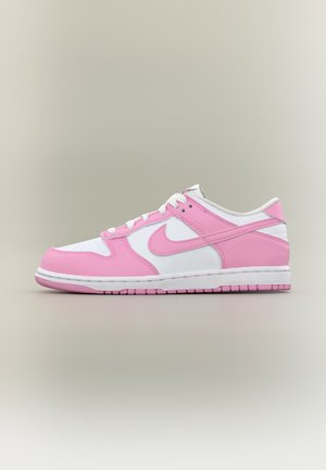 Basket basse en cuir blanc avec des superpositions roses, le logo Nike en rose, des lacets blancs, et une semelle en caoutchouc rose et blanche, vue de côté.