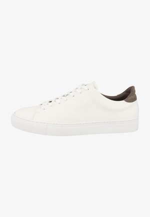 White leather sneaker with round toe, flat white sole, and a brown suede heel accent. Features six eyelets and simple lace design.